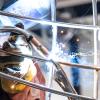 Closeup of a welding torch joining stainless steel metal pieces.
