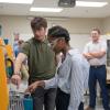 Two people wearing safety goggles interact with the controls on an injection molder in a Pennsylvania College of Technology polymers lab.