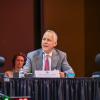 Penn College President Michael J. Reed sits at a table on a stage and speaks into a microphone.