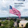 Cover of Penn College Magazine, showing the large flag near the college's entrance.