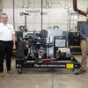 Two men stand on either side of an MTU gaseous-fueled generator set in a Penn College lab.