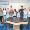 A group of 11 Penn College students poses for a photo in a biology lab.