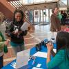 Alumna Joni Bilbay (in green scarf) and Maria Cockerham (seated), both of HCR ManorCare, talk with a student.