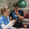 Erin J. McMurray, lab supervisor for the Physical Fitness Specialist Program, helps a Bloomsburg Area High School student with an electronic body fat analyzer.