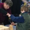 Marc E. Bridgens, dean of construction and design technologies, helps a young man build a souvenir toolbox in a perennial crowd-pleaser.